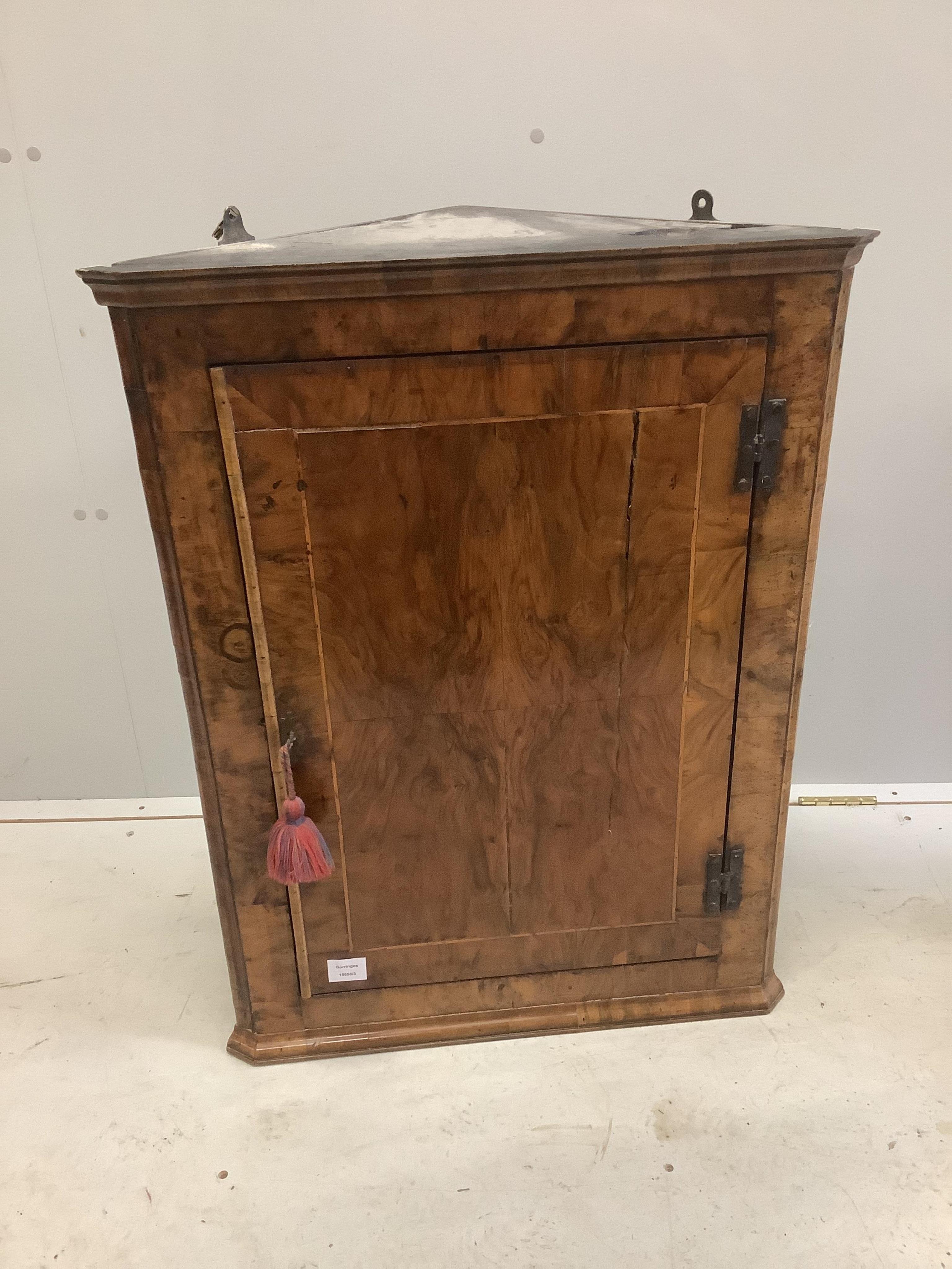 An 18th century banded walnut hanging corner cupboard, width 64cm, depth 32cm, height 83cm. Condition - fair